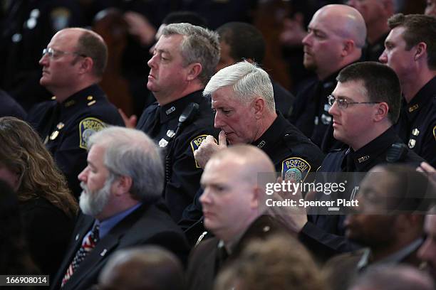Boston police officers listen as Barack Obama speaks at an interfaith prayer service for victims of the Boston Marathon attack titled "Healing Our...