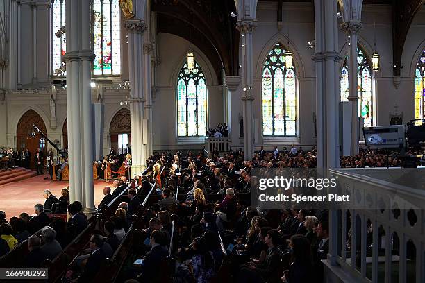 People listen as President Barack Obama speaks at an interfaith prayer service for victims of the Boston Marathon attack titled "Healing Our City,"...