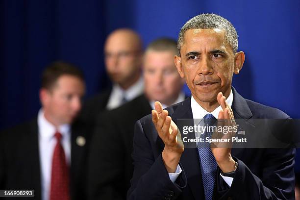 President Barack Obama pauses before speaking to runners and Boston Marathon volunteers at Cathedral High School after attending an interfaith prayer...