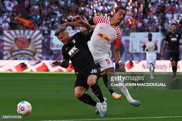 Augsburg's German midfielder Niklas Dorsch and Leipzig's Danish forward Yussuf Poulsen vie for the ball during the German first division Bundesliga...