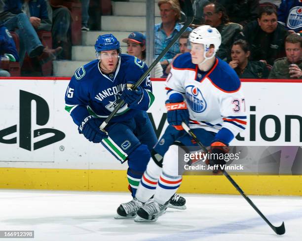 Lennart Petrell of the Edmonton Oilers and Derek Roy of the Vancouver Canucks skates up ice during their NHL game at Rogers Arena April 4, 2013 in...