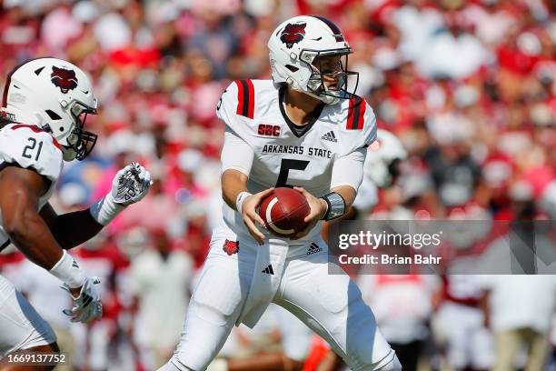 Quarterback J.T. Shrout of the Arkansas State Red Wolves drops back to hand the ball off to running back Zak Wallace against the Oklahoma Sooners in...