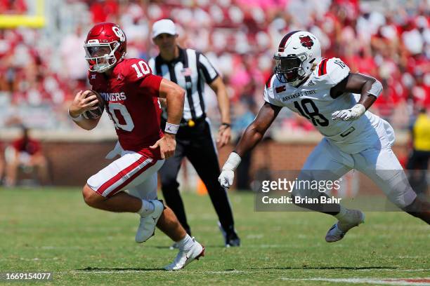 Quarterback Jackson Arnold of the Oklahoma Sooners takes off for the sideline and a six-yard gain against defensive end Dennard Flowers of the...