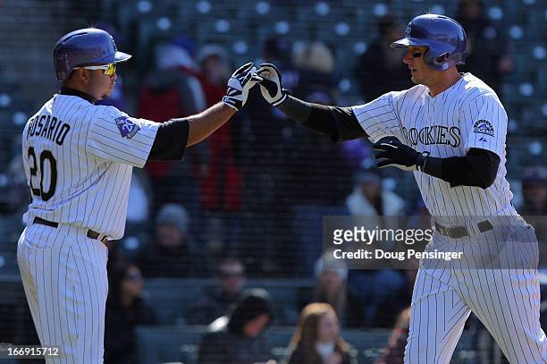 Troy Tulowitzki of the Colorado Rockies celebrates his solo homerun off of Jeremy Hefner of the New York Mets with Wilin Rosario of the Colorado...