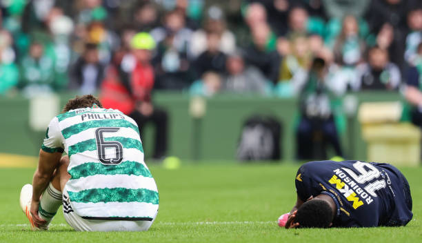 Celtic's Nat Phillips and Dundee's Zach Robinson lie on the ground after colliding during a cinch Premiership match between Celtic and Dundee at...