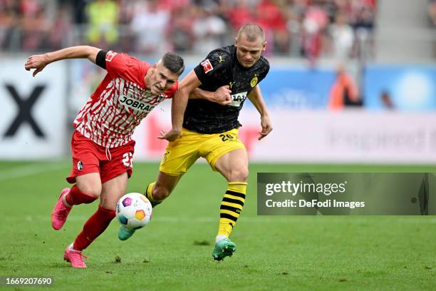 Roland Sallai of SC Freiburg and Julian Ryerson of Borussia Dortmund battle for the ball during the Bundesliga match between Sport-Club Freiburg and...