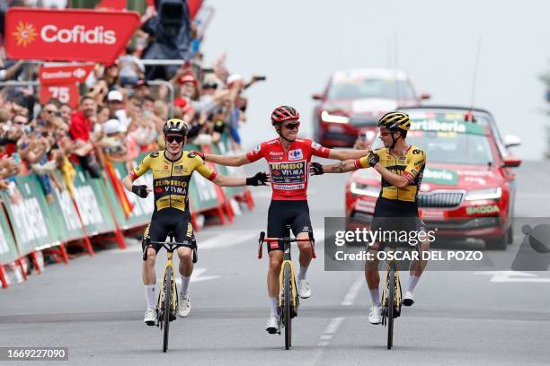 Team Jumbo-Visma's US rider Sepp Kuss, wearing the overall leader jersey celebrates with Team Jumbo-Visma's Danish rider Jonas Vingegaard and Team...