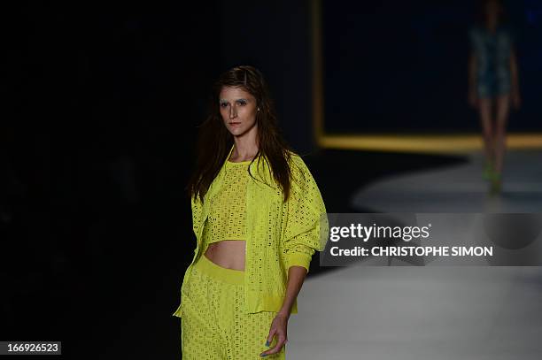 Model presents an outfit of Coca Cola clothing during the Rio Fashion Week in Rio de Janeiro, Brazil on April 18, 2013. AFP PHOTO / CHRISTOPHE SIMON