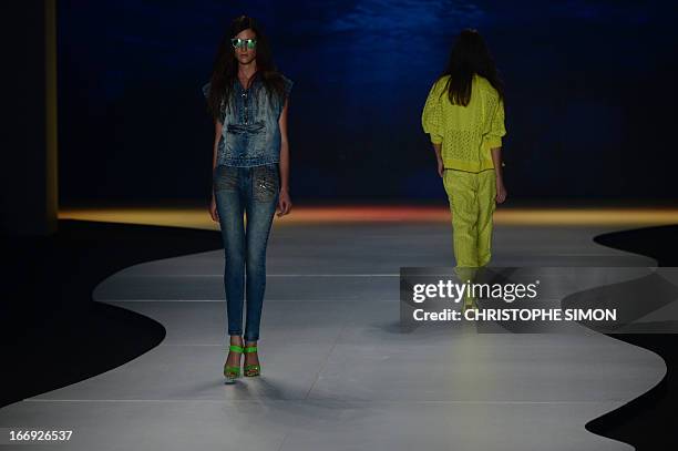 Models present outfits of Coca Cola clothing during the Rio Fashion Week in Rio de Janeiro, Brazil on April 18, 2013. AFP PHOTO / CHRISTOPHE SIMON