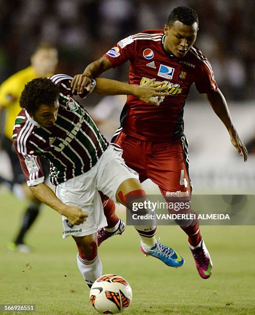 Wellington Nem of Brazil’s Fluminense, vies for the ball with Amaral of Venezuela’s Caracas FC, during their 2013 Copa Libertadores football match...