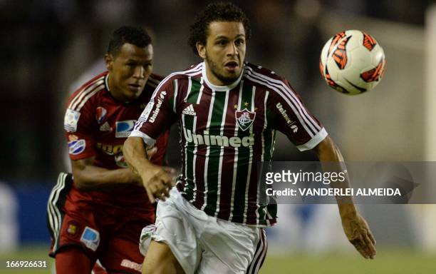 Wellington Nem of Brazil’s Fluminense, vies for the ball with Amaral of Venezuela’s Caracas FC, during their 2013 Copa Libertadores football match...