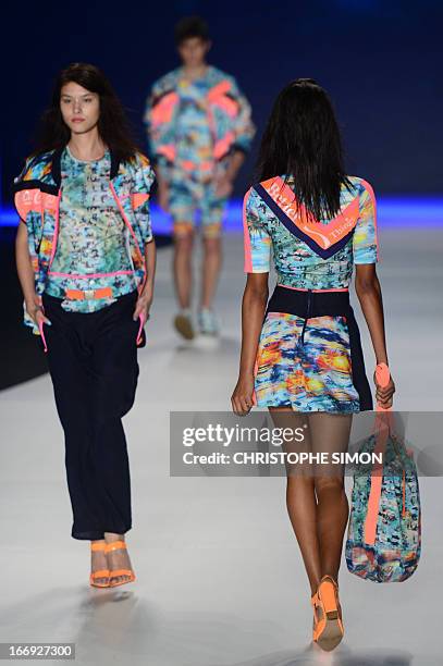 Models present outfits of Coca Cola clothing during the Rio Fashion Week in Rio de Janeiro, Brazil on April 18, 2013. AFP PHOTO / CHRISTOPHE SIMON