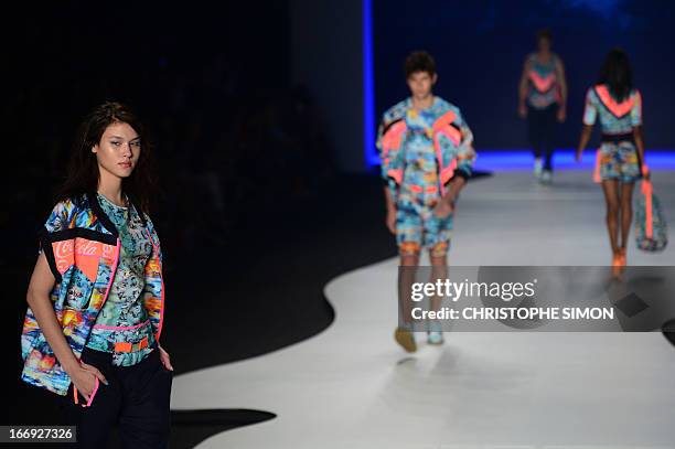 Mdels present outfits of Coca Cola clothing during the Rio Fashion Week in Rio de Janeiro, Brazil on April 18, 2013. AFP PHOTO / CHRISTOPHE SIMON