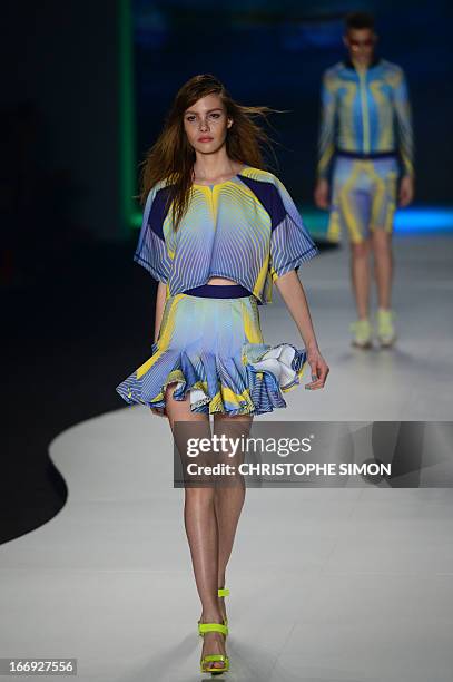 Model presents an outfit of Coca Cola clothing during the Rio Fashion Week in Rio de Janeiro, Brazil on April 18, 2013. AFP PHOTO / CHRISTOPHE SIMON