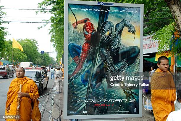 Monks walk past a poster announcing the next episode of the movie "Spiderman" as they demonstrate outside the parliament to demand that the new...