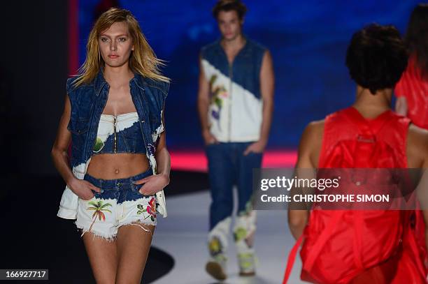 Model present outfits of Coca Cola clothing during the Rio Fashion Week in Rio de Janeiro, Brazil on April 18, 2013. AFP PHOTO / CHRISTOPHE SIMON