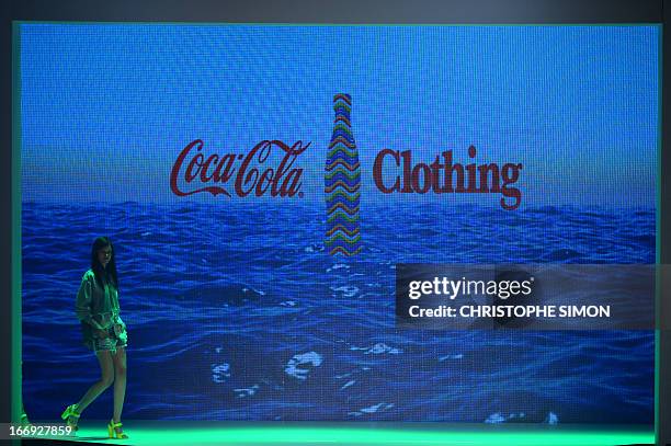 Model presents an outfit of Coca Cola clothing during the Rio Fashion Week in Rio de Janeiro, Brazil on April 18, 2013. AFP PHOTO / CHRISTOPHE SIMON