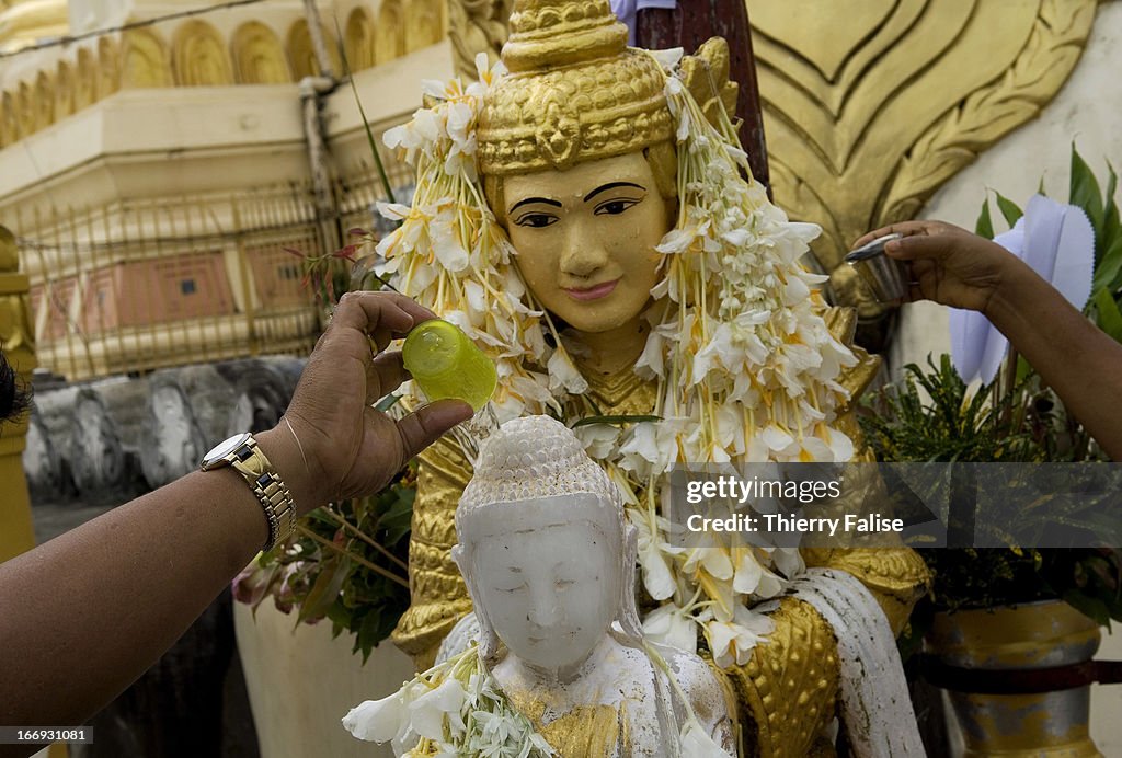 People pour water on a Buddha statue at the Shwedagon Pagoda...