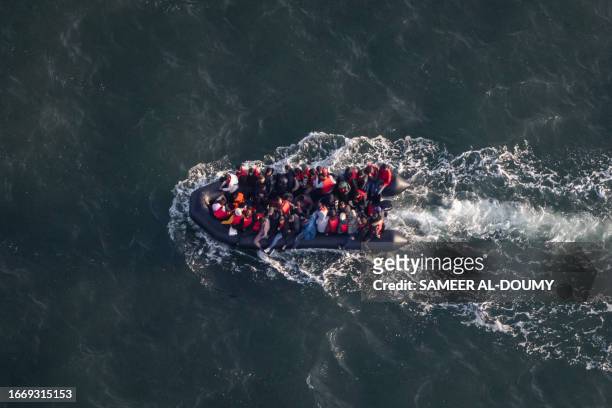 This aerial picture taken on September 16 from a police aircraft belonging to the French Police Aux Frontieres shows migrants onboard of a dinghy...