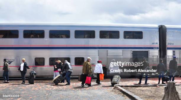 Train passengers board Amtrak's Southwest Chief at the Amtrak station in Lamy, New Mexico. The train runs daily between Los Angeles and Chicago, with...