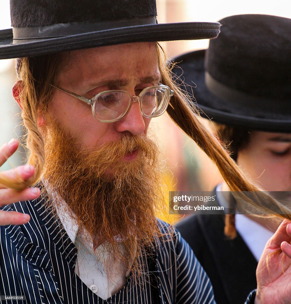 An Ultra-Orthodox Jew praying and curling Payot