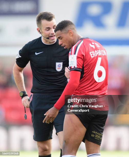 Lincoln City's Ethan Erhahon shows stud marks, caused by Carlisle United's Owen Moxon, on his thigh to referee Tom Nield during the Sky Bet League...