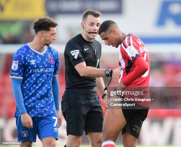 Lincoln City's Ethan Erhahon shows stud marks, caused by Carlisle United's Owen Moxon, on his thigh to referee Tom Nield during the Sky Bet League...