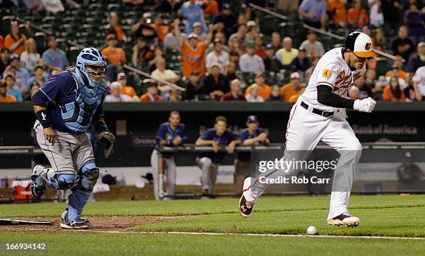 Catcher Jose Molina of the Tampa Bay Rays goes after the ball as Manny Machado of the Baltimore Orioles lays down a bunt and is safe at first base...