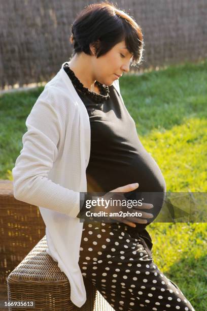 mujer embarazada sentada en un jardin - mujer sentada stock pictures, royalty-free photos & images