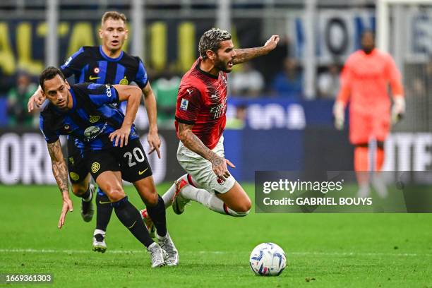 Inter Milan's Turkish midfielder Hakan Calhanoglu fights for the ball with AC Milan's French defender Theo Hernandez during the Italian Serie A...