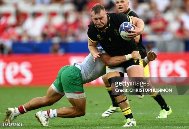 Wales' hooker and captain Dewi Lake is tackled as he runs with the ball during the France 2023 Rugby World Cup Pool C match between Wales and...