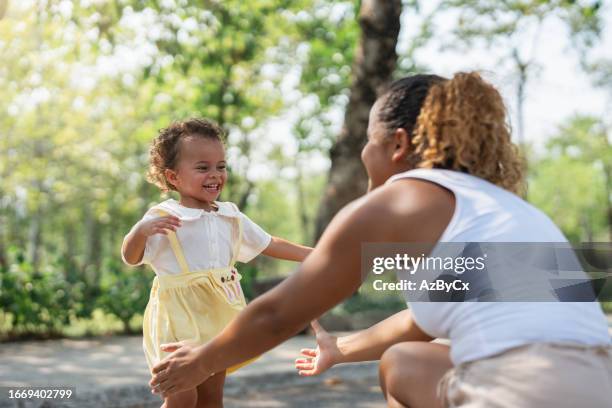 mom playing with their smiling children in the playground - cute college girl stock pictures, royalty-free photos & images