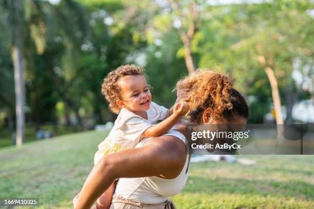 mom playing with their kid in the park - cute college girl stock pictures, royalty-free photos & images