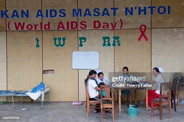 People who have fled their village in the aftermath of fighting between the Burmese army and the Kachin Independence Army consult a clinic in Manau,...