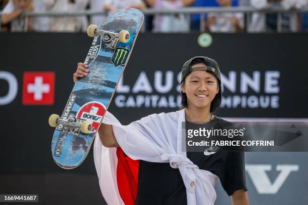 Japan's Toa Sasaki wears the Japanese flag as he celebrates on the podium after winning 2nd place in the men's skateboarding street final of...