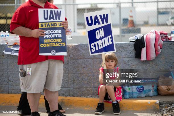 Young supporter holds a sign as United Auto Workers members strike at the Ford Michigan Assembly Plant on September 16, 2023 in Wayne, Michigan. This...