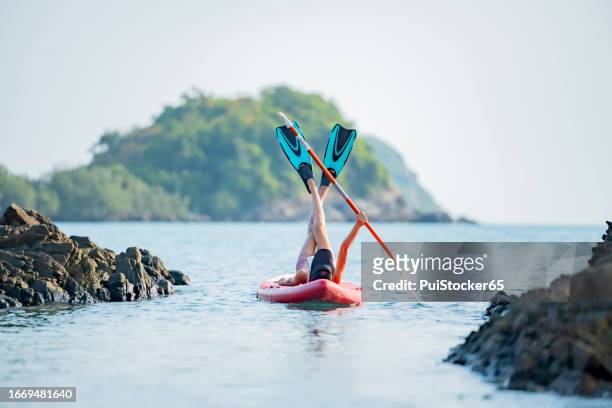 asian athletic woman on paddle board at the sea. solo outdoor water sport and travel on summer holiday thailand. - similan islands stock pictures, royalty-free photos & images