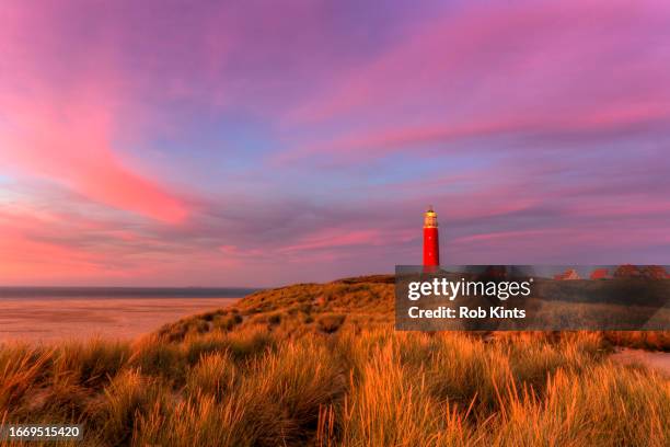 texel lighthouse near de cocksdorp and a beautiful afterglow in the sky - red beacon stock pictures, royalty-free photos & images