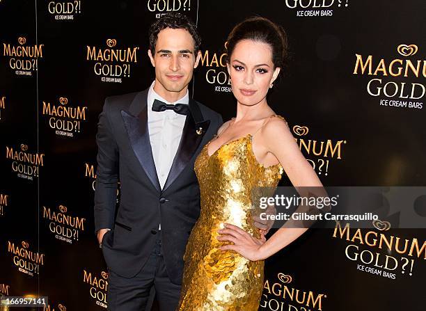 Designer Zac Posen and actress Caroline Correa wearing a Zac Posen one-of-a-kind 24k gold dress valued at $1.5 million attend the premiere of "As...