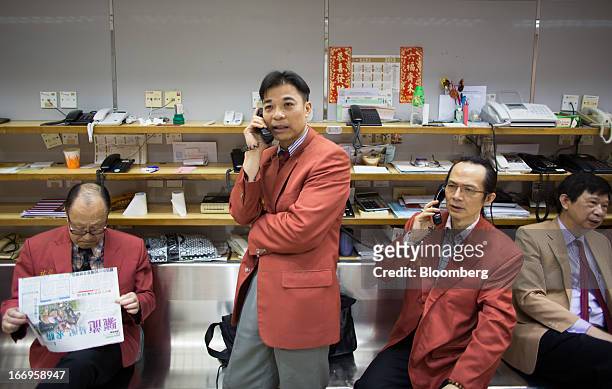 Traders speak on the telephone in the trading hall of The Chinese Gold and Silver Exchange Society in Hong Kong, China, on Friday, April 19, 2013....