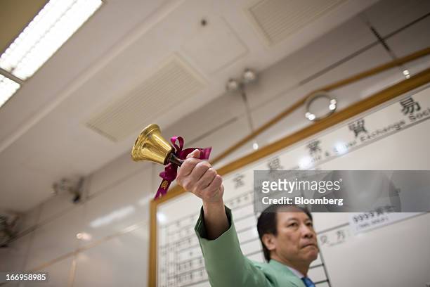 An employee of The Chinese Gold and Silver Exchange Society rings a bell to mark the end of a trading session in the society's trading hall in Hong...