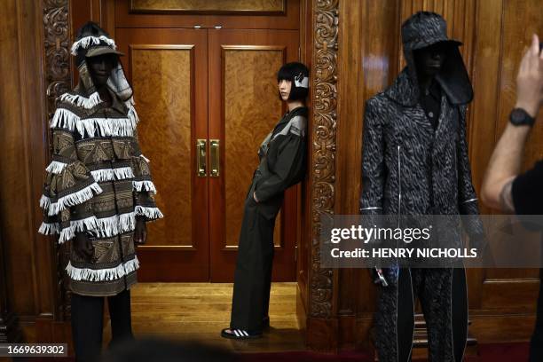 Models pose for pictures and have their final preparations made backstage ahead of the catwalk presentation for London-based label Labrum's...