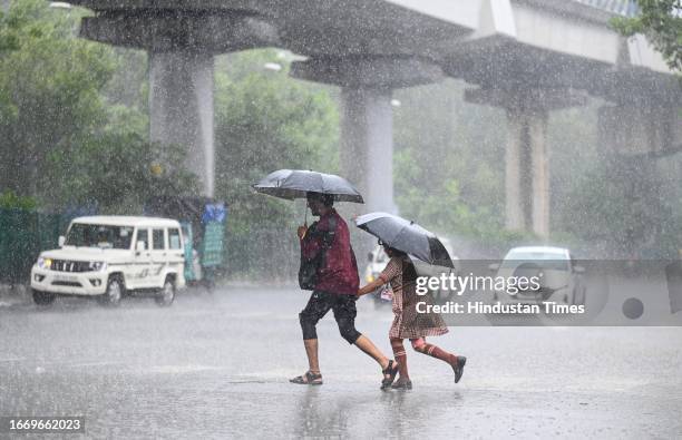 Commuters seen during heavy rains at Panchkuian Road, on September 16, 2023 in New Delhi, India.