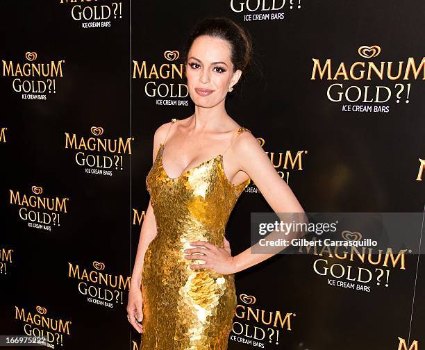 Actress Caroline Correa poses wearing a Zac Posen one-of-a-kind 24k gold dress valued at $1.5 million at the premiere of "As Good As Gold" during the...
