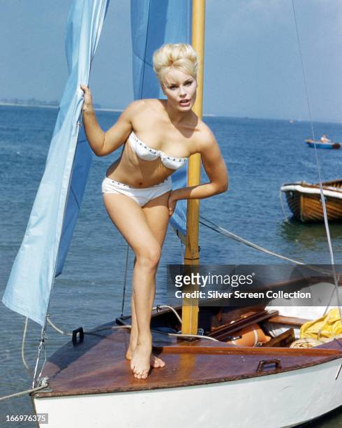 German actress Elke Sommer wearing a bikini and standing on the deck of a sailing dinghy, circa 1963.
