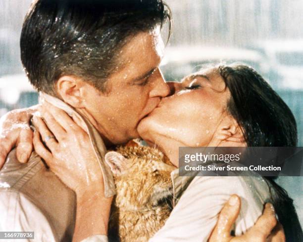 Paul Varjak, played by George Peppard , and Holly Golightly, played by Audrey Hepburn , kiss in a publicity still from 'Breakfast at Tiffany's',...