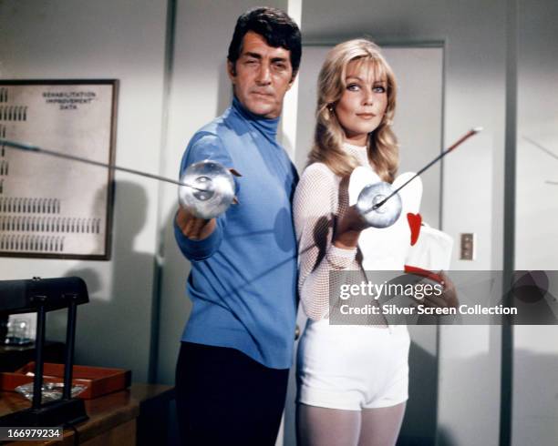 American actor and singer Dean Martin , as Matt Helm, and Austrian actress Senta Berger, as Francesca Madeiros, holding fencing foils in a publicity...