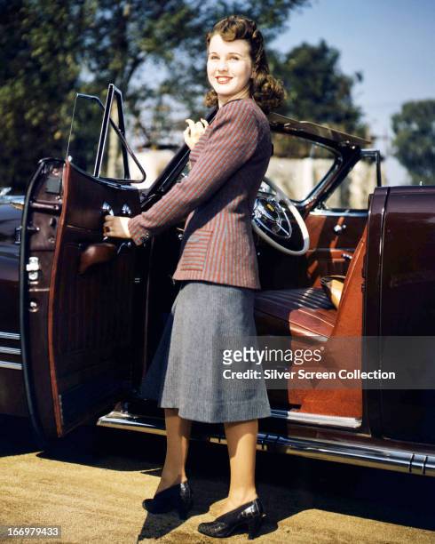 Canadian actress Deanna Durbin getting into convertible car, circa 1945.