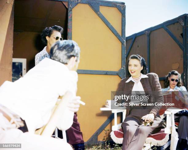 American actress Barbara Stanwyck on a film set, circa 1940.