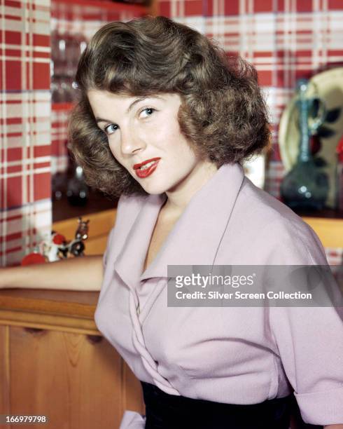 French actress Corinne Calvet wearing a mauve blouse, circa 1950.